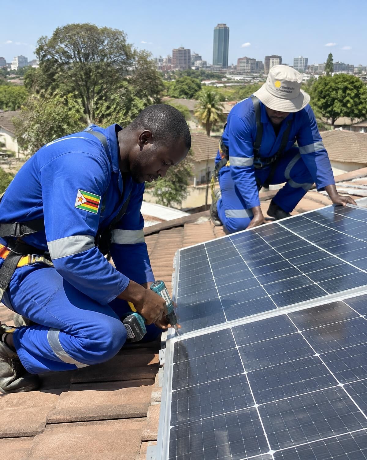 Evvo technicians installing solar panels on a Harare roof